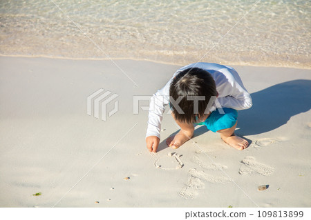 child drawing on the sand 109813899