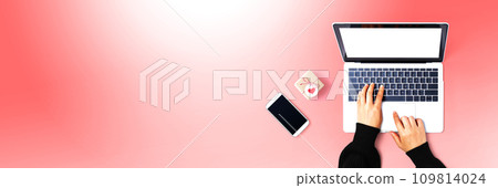 Person using a laptop computer with a small gift box 109814024