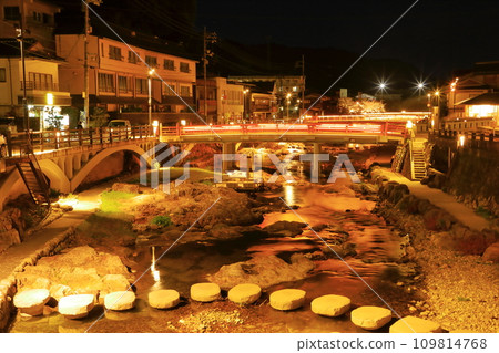 Night in Nagato Yumoto Onsen town, stepping stones and Chiyobashi bridge illuminated 109814768