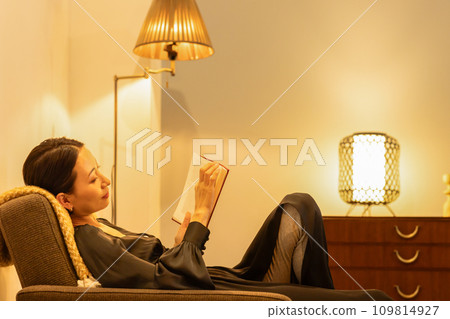 A woman reading in her room at night 109814927