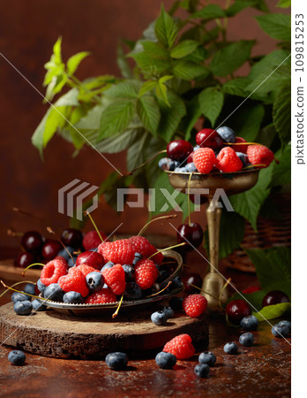 Berries with leaves on an old brown table. 109815253