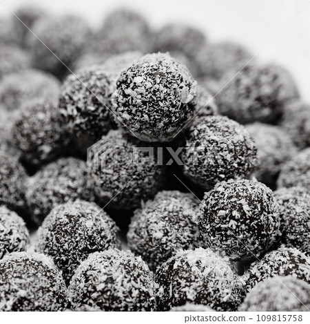 Rum balls in coconut. Traditional unbaked Czech sweets for Christmas and winter. Raw sweet food with cocoa and coconut. Rum balls in coconut. Traditional unbaked Czech sweets for Christmas and winter. Raw sweet food with cocoa and coconut. 109815758