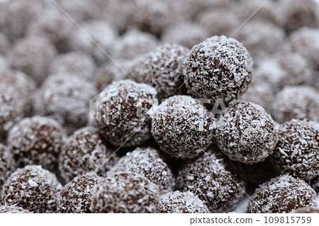 Rum balls in coconut. Traditional unbaked Czech sweets for Christmas and winter. Raw sweet food with cocoa and coconut. Rum balls in coconut. Traditional unbaked Czech sweets for Christmas and winter. Raw sweet food with cocoa and coconut. 109815759