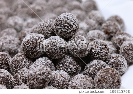 Rum balls in coconut. Traditional unbaked Czech sweets for Christmas and winter. Raw sweet food with cocoa and coconut. Rum balls in coconut. Traditional unbaked Czech sweets for Christmas and winter. Raw sweet food with cocoa and coconut. 109815768