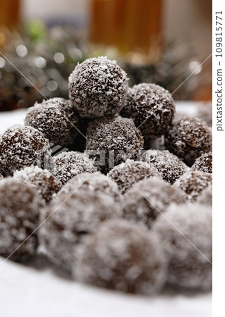 Rum balls in coconut. Traditional unbaked Czech sweets for Christmas and winter. Raw sweet food with cocoa and coconut. Rum balls in coconut. Traditional unbaked Czech sweets for Christmas and winter. Raw sweet food with cocoa and coconut. 109815771