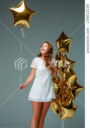 Portrait young attractive woman in white dress, holding bunch of 109818189