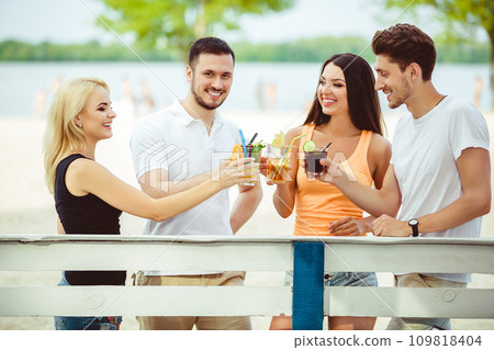 Friends having fun at the bar outdoors, drinking cocktails. Friends having fun at the bar outdoors, drinking cocktails. 109818404