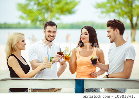 Friends having fun at the bar outdoors, drinking cocktails. Friends having fun at the bar outdoors, drinking cocktails. 109818413