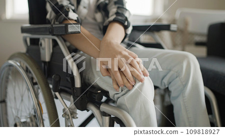Boy feeling pain in knees, sitting in wheelchair, rehabilitation after injury Boy feeling pain in knees, sitting in wheelchair, rehabilitation after injury 109818927