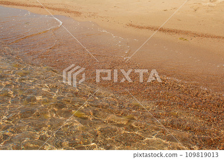 Sand and pebbles seashore with wave on sunny day. Vacation, travel, landscape. Copy space Sand and pebbles seashore with wave on sunny day. Vacation, travel, landscape. Copy space 109819013