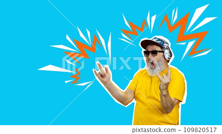 Rock and roll. Senior excited man listening to music in headphones over blue background. Creative design. 109820517