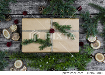 Gift box and decoration .Christmas tree branches and pine cones wooden background. Flat lay, top view. 109820800