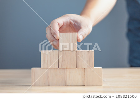 hand of a businessman stacking wood empty eight blocks with copy space for text or symbols, development concept for growth success process. hand of a businessman stacking wood empty eight blocks with copy space for text or symbols, development concept for growth success process. 109821506
