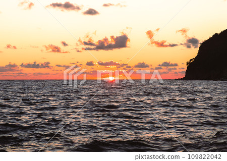 Sunset over the sea. The Sun and beautiful clouds at the horizon Sunset over the sea. The Sun and beautiful clouds at the horizon 109822042