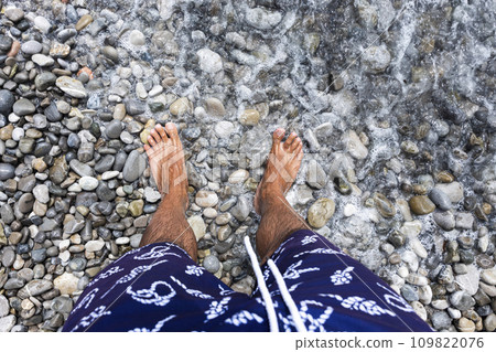 Mans feet .Standing on a rocky beach barefoot Mans feet .Standing on a rocky beach barefoot 109822076