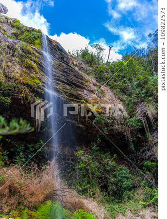 Waterfall Long Exposure with Blue Sky and Verdant Forest 109822573