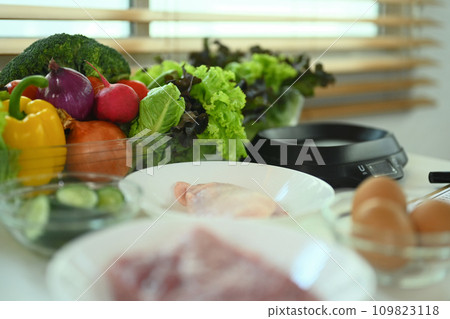 Fresh vegetables and raw meat on table in kitchen. Healthy food, nutritious and culinary concept. Fresh vegetables and raw meat on table in kitchen. Healthy food, nutritious and culinary concept. 109823118