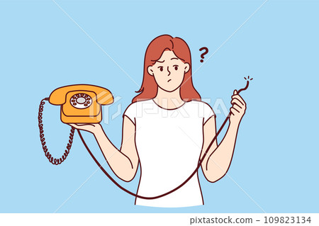 Embarrassed woman holding retro telephone with torn wire, and is wondering how to restore telephony 109823134