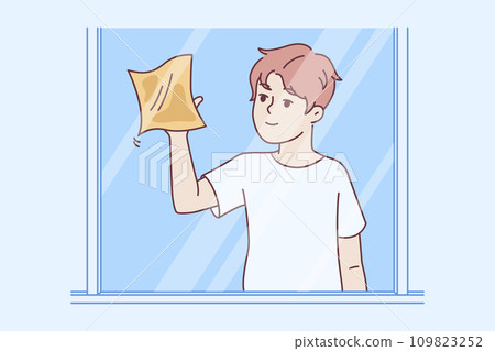 Neat boy is doing cleaning and wipes mirror or window from stains to comply with rules of sanitation 109823252