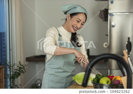 圍裙的女人用刀切大白菜 109823262