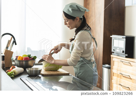 圍裙的女人用刀切大白菜 圍裙的女人用刀切大白菜 109823266