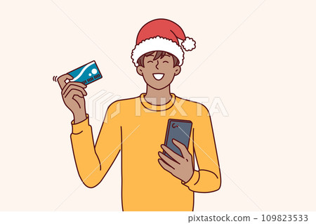 Christmas man shopaholic holds phone and credit card for online purchase goods with courier delivery 109823533