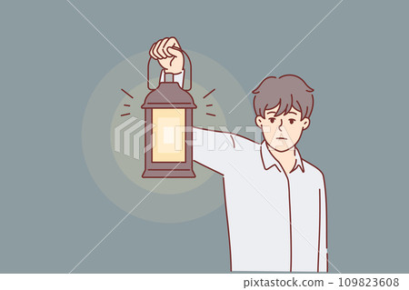 Man with kerosene lamp lights way in dark, looking for exit out room, metaphor for difficult times 109823608