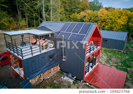 New modern house cottage with solar photovoltaic panel system on roof. Aerial view. Concept of alternative, renewable energy and home autonomy. New modern house cottage with solar photovoltaic panel system on roof. Aerial view. Concept of alternative, renewable energy and home autonomy. 109823766