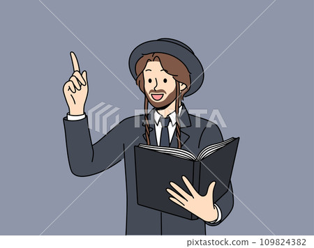 Jewish man holds book with religious texts and points finger up talking about israelite religion 109824382