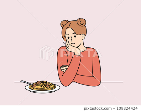 Woman experiences lack of appetite and sadly looks at plate of spaghetti due to bulimia 109824424