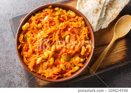 Chakalaka is a staple south African dish made from beans, fresh veggies, onions, pepper, and tomatoes closeup on the bowl. Horizontal top view Chakalaka is a staple south African dish made from beans, fresh veggies, onions, pepper, and tomatoes closeup on the bowl. Horizontal top view 109824598
