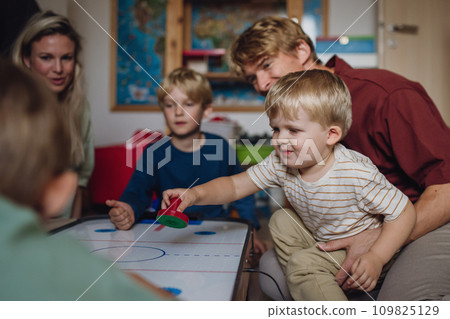 Cheerful family with three kids playing in kids room. Family board game, playtime, having fun together. 109825129