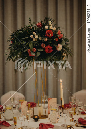 Elegant, romantic table setting for indoor wedding reception. Luxury wedding table decoration, special event table set up with fresh flowers arragements on high stands. Elegant, romantic table setting for indoor wedding reception. Luxury wedding table decoration, special event table set up with fresh flowers arragements on high stands. 109825143