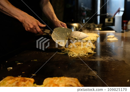 A man making okonomiyaki A man making okonomiyaki 109825170