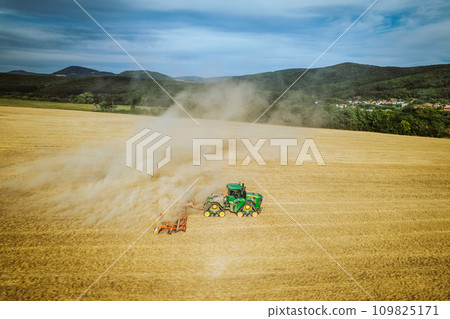 Aerial view of a harvester working in a field. Agriculture and cultivation of industrial farms. Agribusiness. 109825171