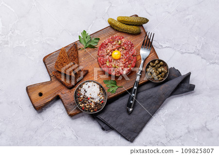 Savory beef tartare and brown bread toasts 109825807