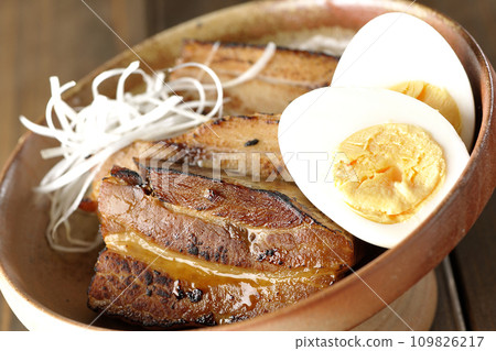 Thickly sliced char siu topped with white onion and boiled egg 109826217