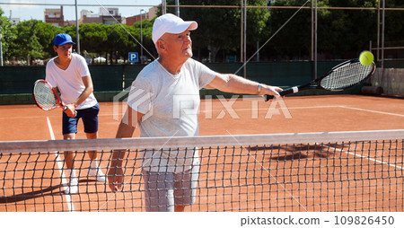Grandfather and grandson playing tennis court Grandfather and grandson playing tennis court 109826450