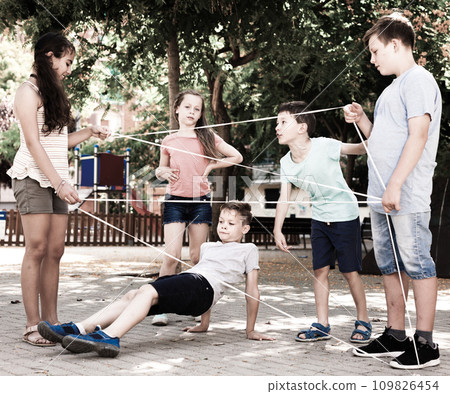 Children's games. The boy carefully walks along the tangled rope Children's games. The boy carefully walks along the tangled rope 109826454