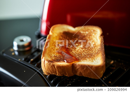Breakfast time. Bread toast in the toaster. 109826994