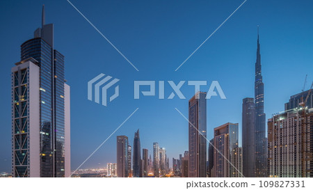 Aerial sunrise view of Dubai Downtown skyline with many towers night to day timelapse. 109827331