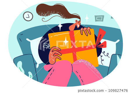 Smiling girl sit on sofa with present 109827476