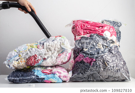 Pumping out air from a vacuum bag with a vacuum cleaner for storing compact-sized items and clothes. 109827810