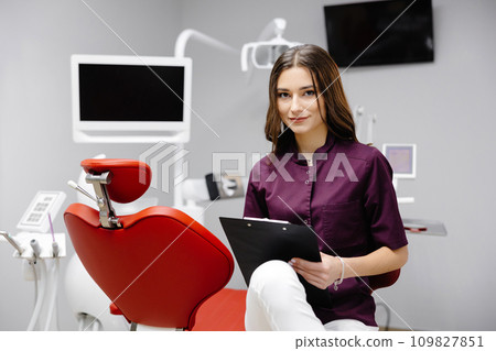 Doctor dentist working in office, using clipboard and making notes Doctor dentist working in office, using clipboard and making notes 109827851