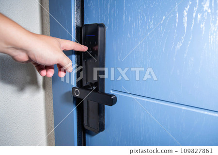 A man opens a door with an electronic lock using an access password. Modern electronic reliable locks for entrance doors. Copy space for text 109827861