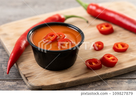 Spicy chili sauce in a bowl on wooden table 109827879