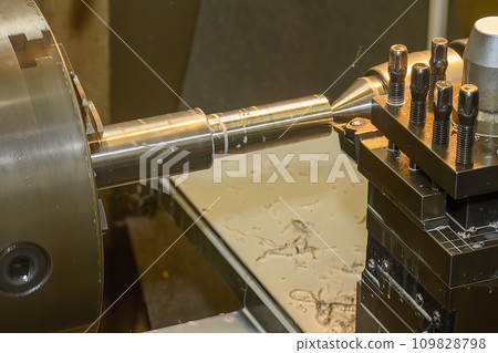 The lathe machine finish cut  metal shaft parts with liquid coolant method. 109828798