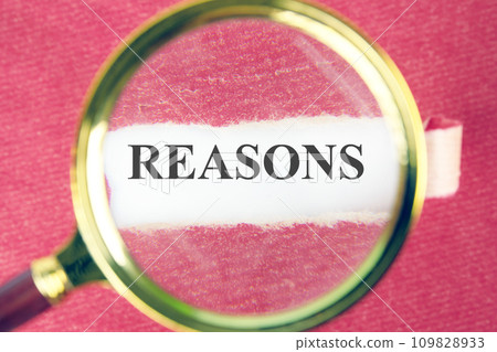 REASONS the text, the word can be seen through a magnifying glass on torn paper REASONS the text, the word can be seen through a magnifying glass on torn paper 109828933