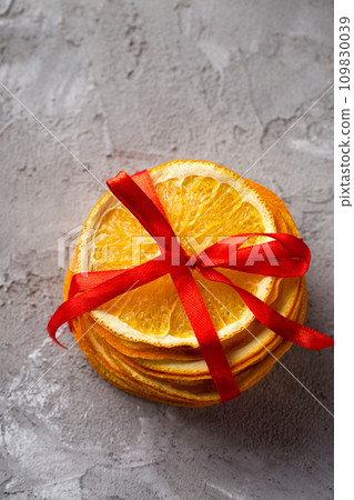 Dry candied orange slices on a gray textured background Dry candied orange slices on a gray textured background 109830039