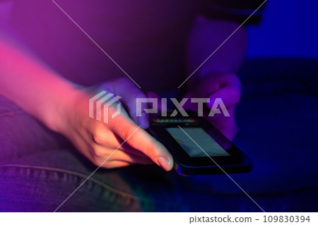 Happy girl checking social media and holding smartphone at home Happy girl checking social media and holding smartphone at home 109830394